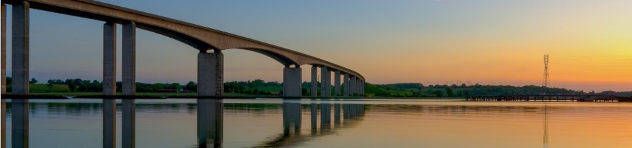 Puente sobre aguas calmas y atardecer